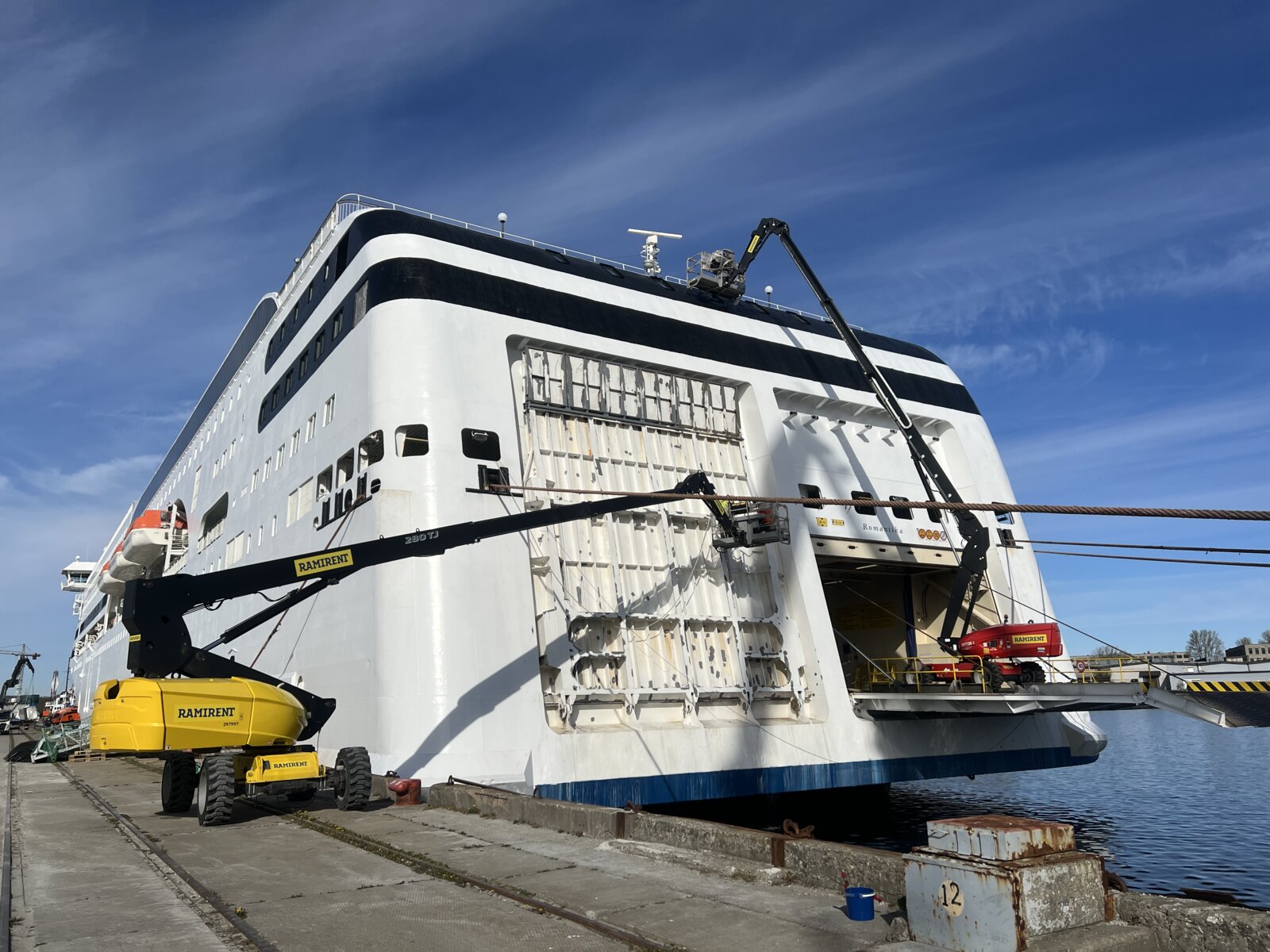 Cherry pickers working the stern ramp area of M/S Romantika during restoration